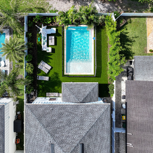 Custom swimming pool surrounded by lush landscaping and outdoor seating