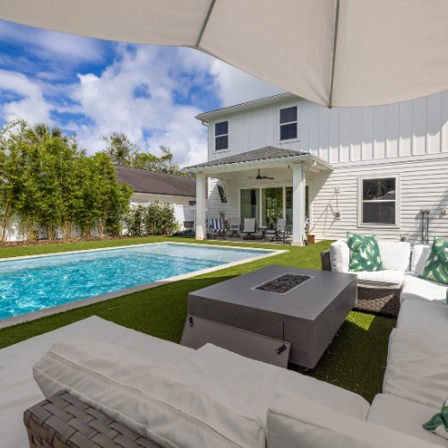 Custom swimming pool surrounded by lush landscaping and outdoor seating