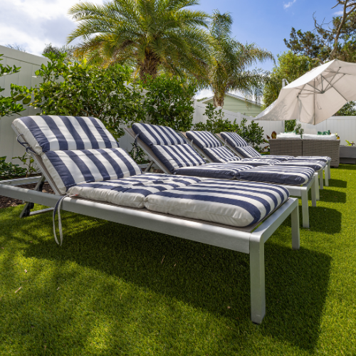 Custom swimming pool surrounded by lush landscaping and outdoor seating