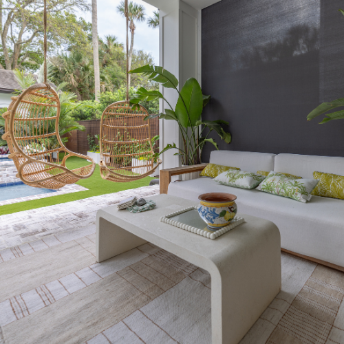 Custom swimming pool surrounded by lush landscaping and outdoor seating