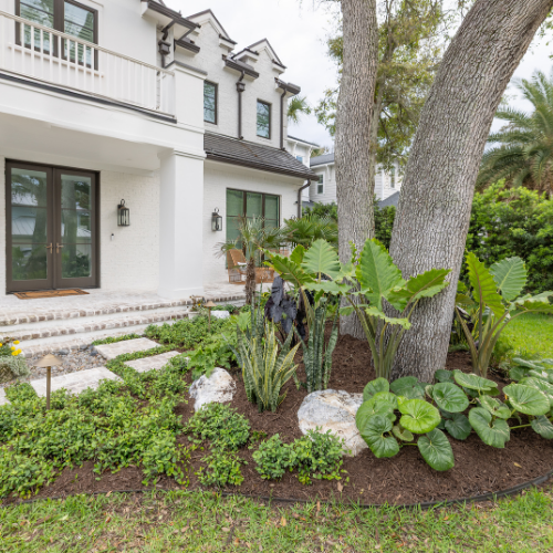 Custom swimming pool surrounded by lush landscaping and outdoor seating