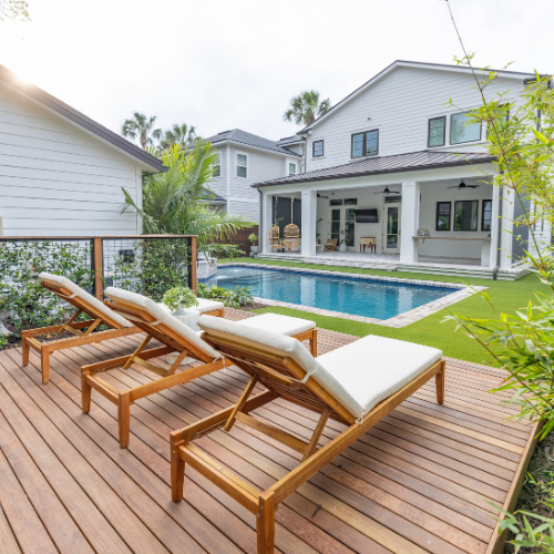 Custom swimming pool surrounded by lush landscaping and outdoor seating